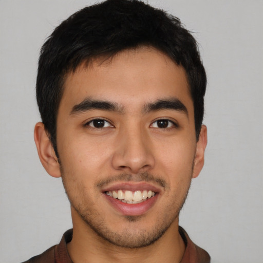 Joyful latino young-adult male with short  brown hair and brown eyes