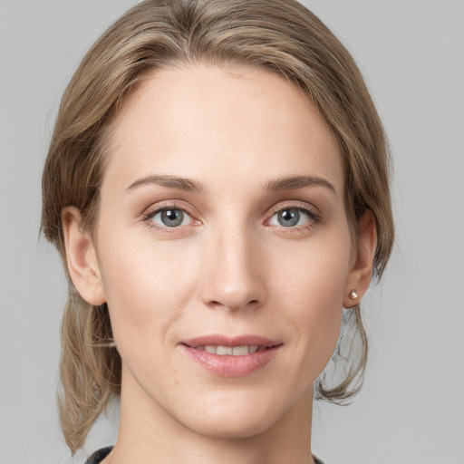 Joyful white young-adult female with medium  brown hair and grey eyes