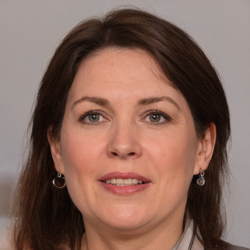 Joyful white adult female with medium  brown hair and grey eyes