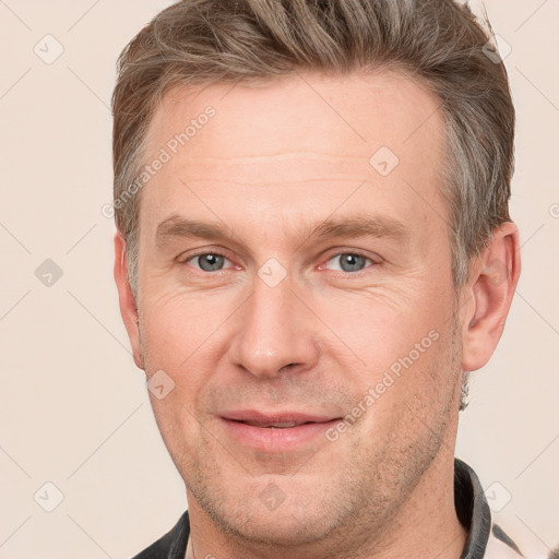 Joyful white adult male with short  brown hair and grey eyes