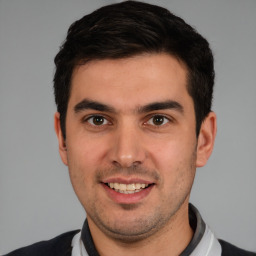 Joyful white young-adult male with short  black hair and brown eyes