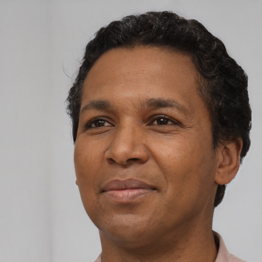 Joyful black adult male with short  brown hair and brown eyes
