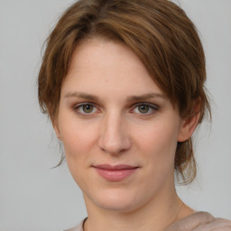 Joyful white young-adult female with medium  brown hair and grey eyes