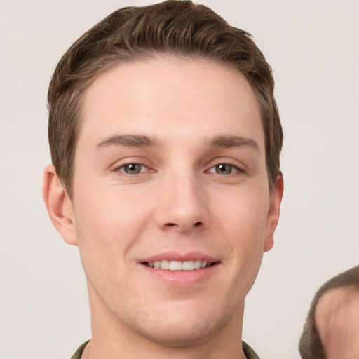 Joyful white young-adult male with short  brown hair and grey eyes