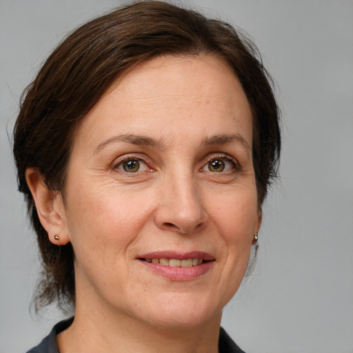 Joyful white adult female with medium  brown hair and grey eyes