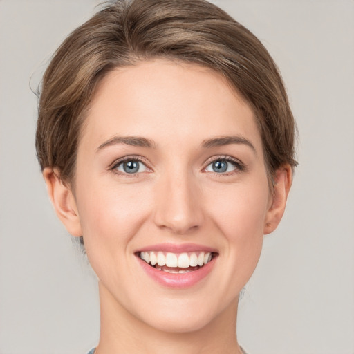 Joyful white young-adult female with short  brown hair and green eyes