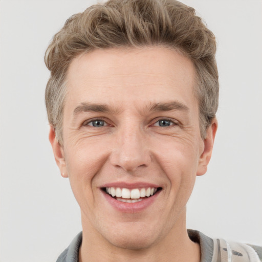 Joyful white adult male with short  brown hair and grey eyes