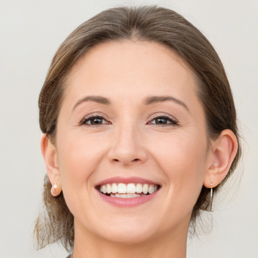 Joyful white young-adult female with medium  brown hair and grey eyes