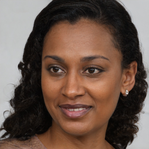 Joyful black young-adult female with medium  brown hair and brown eyes