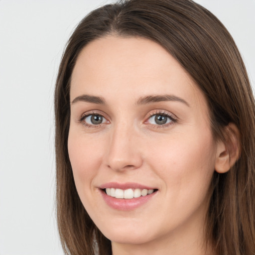 Joyful white young-adult female with long  brown hair and grey eyes