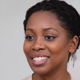 Joyful black young-adult female with long  brown hair and brown eyes