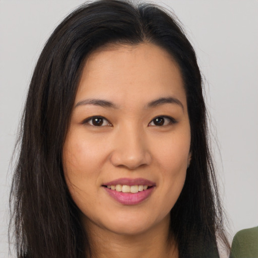 Joyful asian young-adult female with long  brown hair and brown eyes