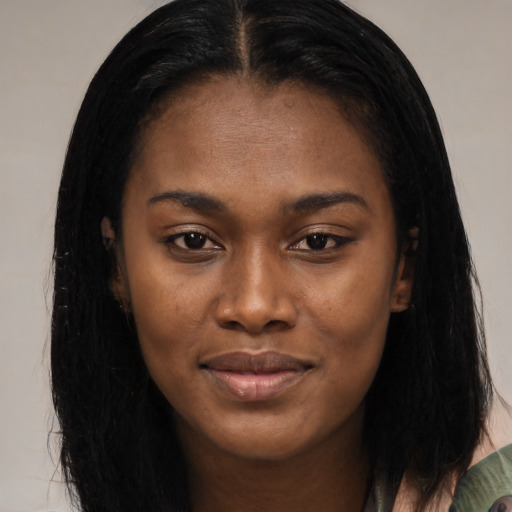 Joyful black young-adult female with long  brown hair and brown eyes