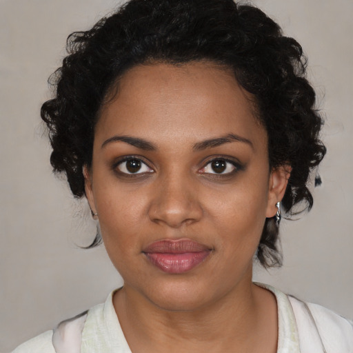 Joyful black young-adult female with medium  brown hair and brown eyes