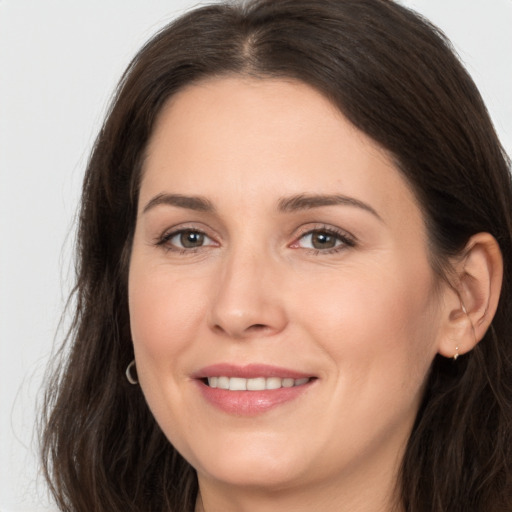 Joyful white young-adult female with long  brown hair and brown eyes