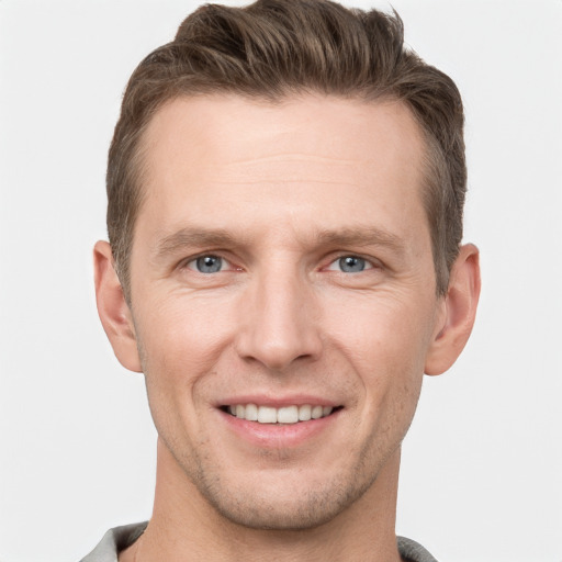 Joyful white young-adult male with short  brown hair and grey eyes