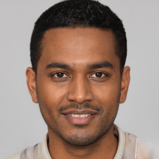 Joyful black young-adult male with short  brown hair and brown eyes