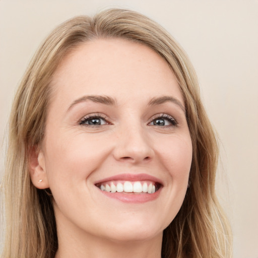 Joyful white young-adult female with long  brown hair and blue eyes