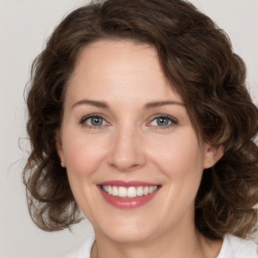 Joyful white young-adult female with medium  brown hair and green eyes