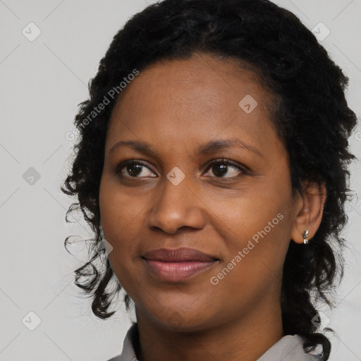 Joyful black young-adult female with long  black hair and brown eyes