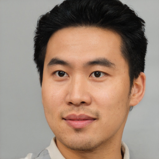 Joyful asian young-adult male with short  brown hair and brown eyes