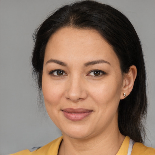 Joyful latino adult female with medium  brown hair and brown eyes