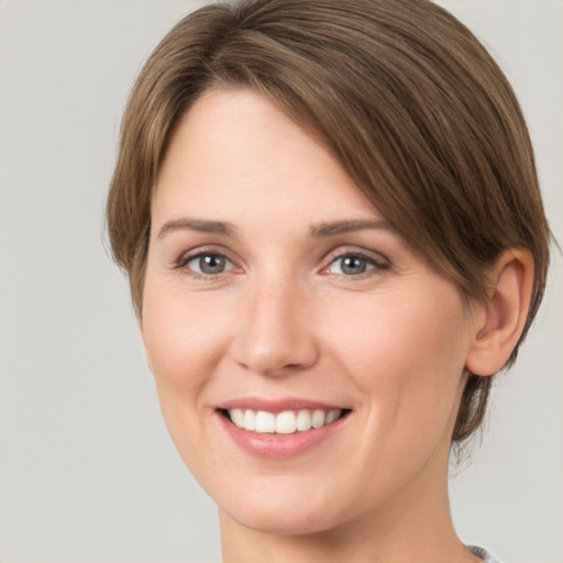 Joyful white young-adult female with medium  brown hair and green eyes