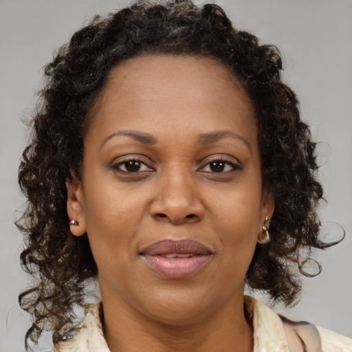 Joyful black adult female with medium  brown hair and brown eyes