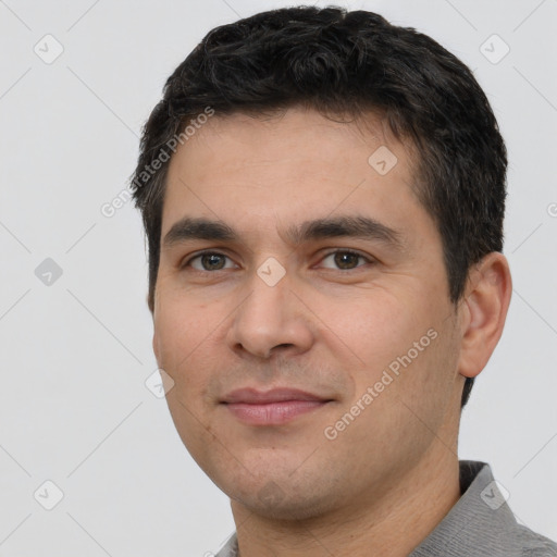 Joyful white young-adult male with short  black hair and brown eyes