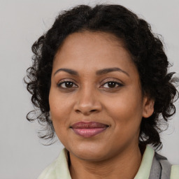 Joyful black adult female with long  brown hair and brown eyes