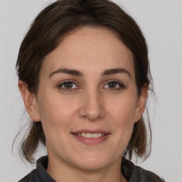 Joyful white young-adult female with medium  brown hair and grey eyes