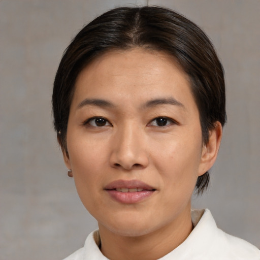 Joyful asian adult female with medium  brown hair and brown eyes