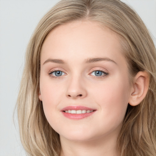 Joyful white young-adult female with long  brown hair and blue eyes