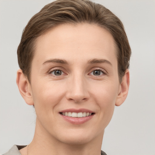 Joyful white young-adult female with short  brown hair and grey eyes