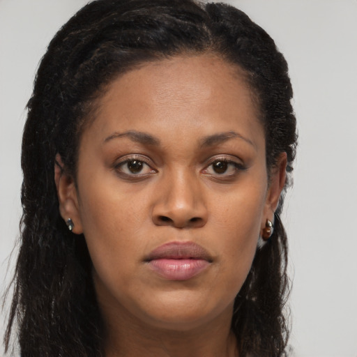 Joyful black young-adult female with long  brown hair and brown eyes