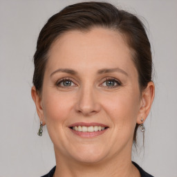 Joyful white adult female with medium  brown hair and grey eyes