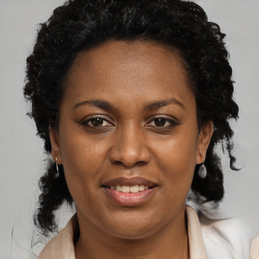 Joyful black young-adult female with medium  brown hair and brown eyes
