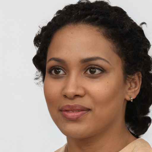 Joyful black young-adult female with long  black hair and brown eyes