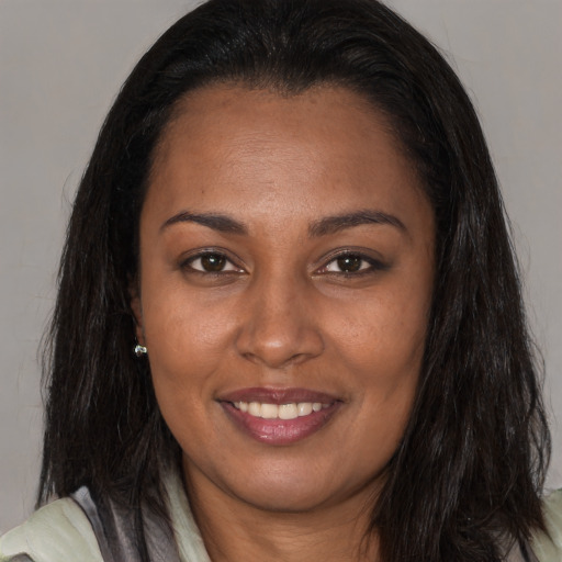 Joyful black adult female with long  brown hair and brown eyes