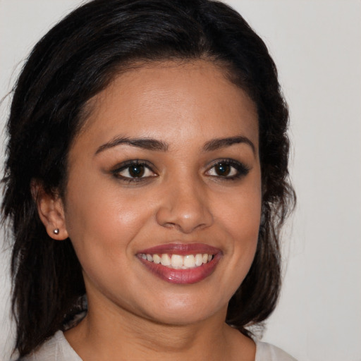 Joyful latino young-adult female with long  brown hair and brown eyes