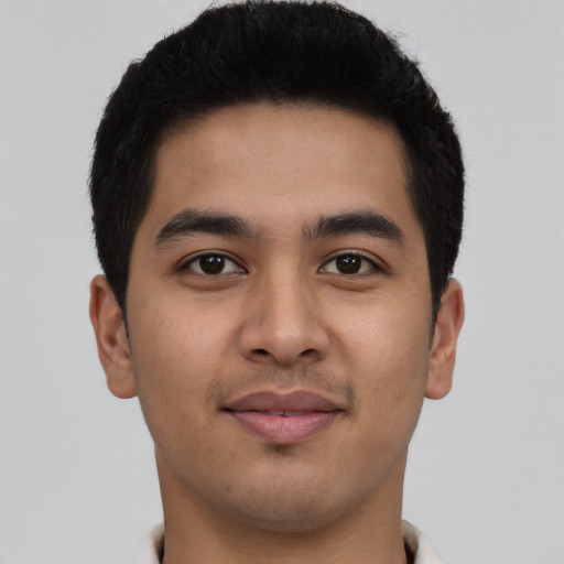 Joyful latino young-adult male with short  black hair and brown eyes