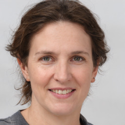 Joyful white adult female with medium  brown hair and grey eyes