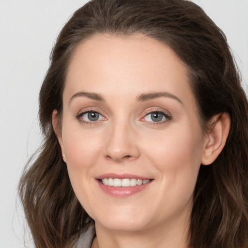 Joyful white young-adult female with long  brown hair and grey eyes