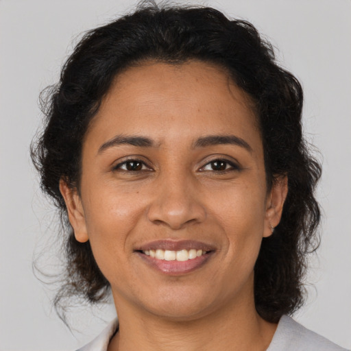 Joyful latino adult female with medium  brown hair and brown eyes