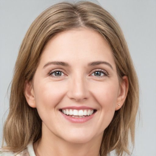 Joyful white young-adult female with medium  brown hair and grey eyes