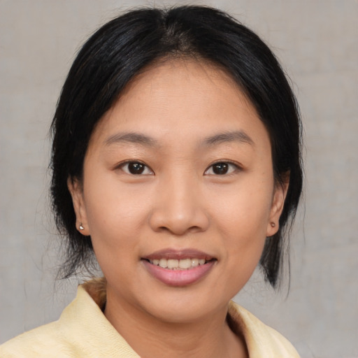 Joyful asian young-adult female with medium  brown hair and brown eyes