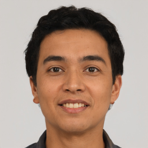Joyful latino young-adult male with short  black hair and brown eyes