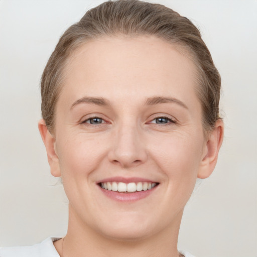 Joyful white young-adult female with short  brown hair and grey eyes