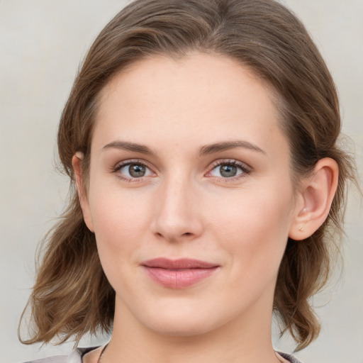 Joyful white young-adult female with medium  brown hair and blue eyes