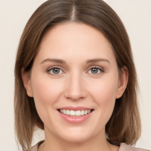 Joyful white young-adult female with medium  brown hair and grey eyes